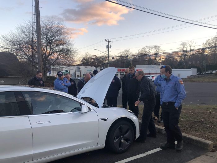 Firefighters observing the wiring on a Tesla Model 3