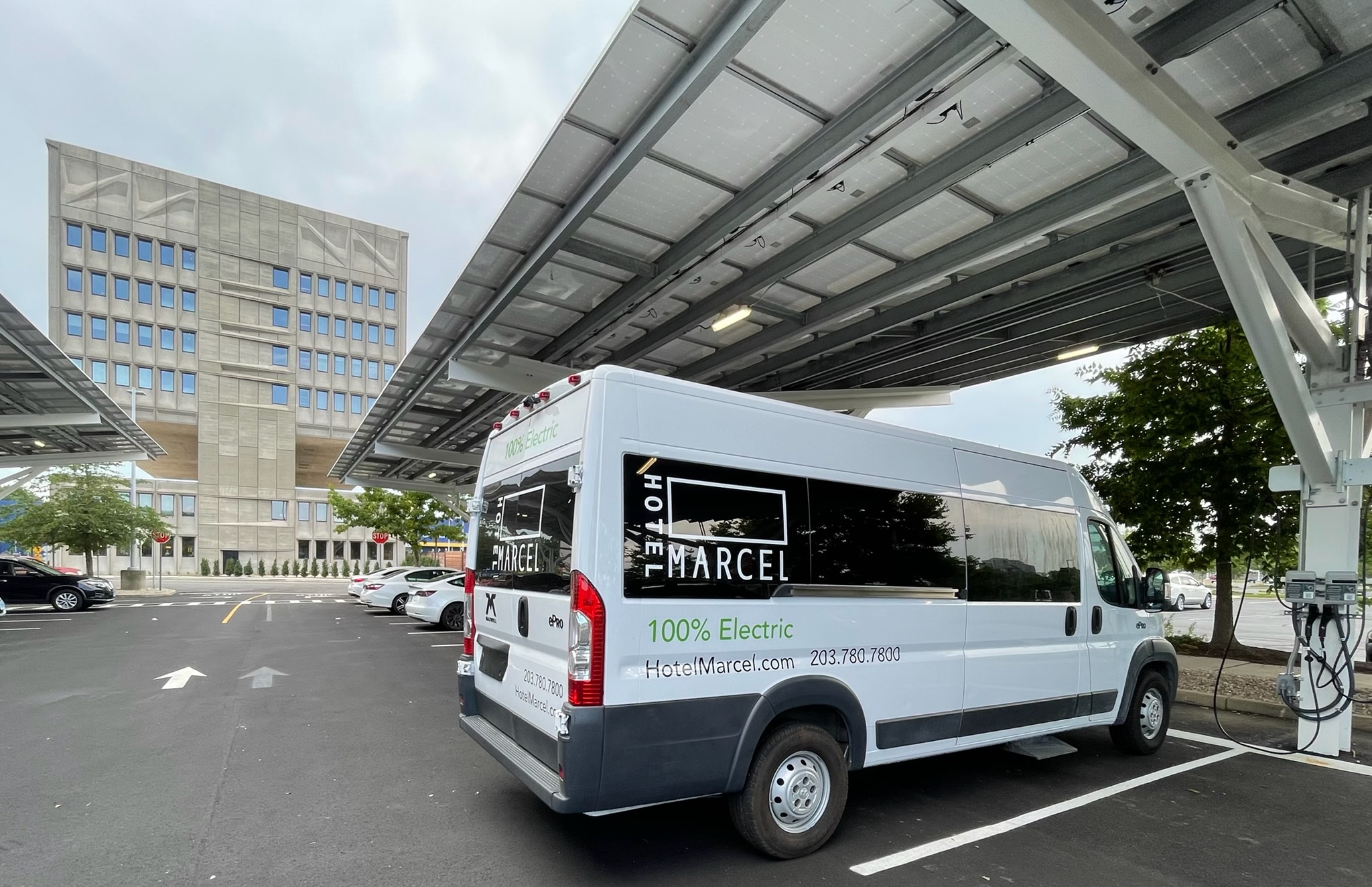 Hotel Marcel New Haven and electric shuttle van with solar canopy and level 2 EV chargers.